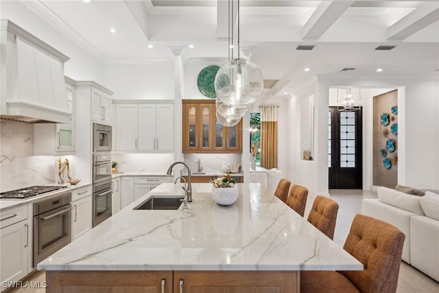 kitchen featuring sink, decorative light fixtures, a large island, and stainless steel gas cooktop