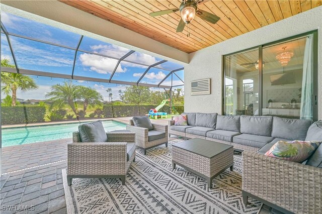 view of patio / terrace featuring a lanai, outdoor lounge area, ceiling fan, and a fenced in pool