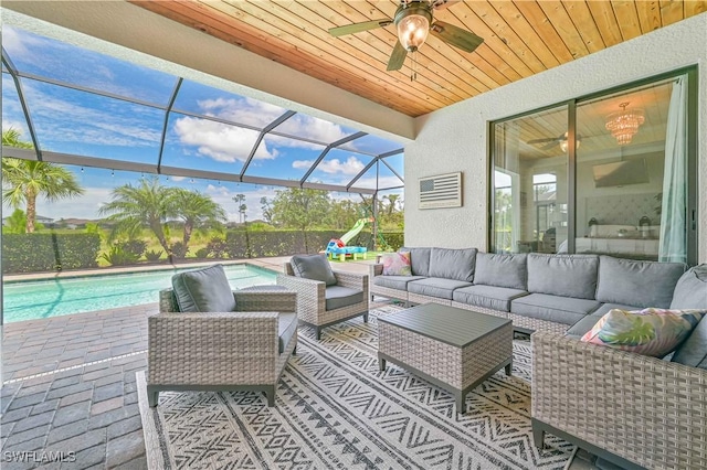 view of patio with a fenced in pool, outdoor lounge area, ceiling fan, and glass enclosure