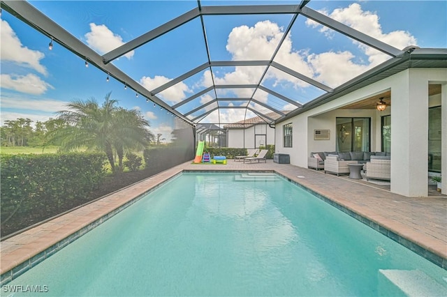 view of swimming pool with a lanai, outdoor lounge area, ceiling fan, and a patio area