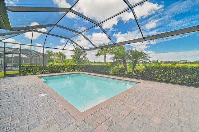 view of swimming pool with a patio area and glass enclosure