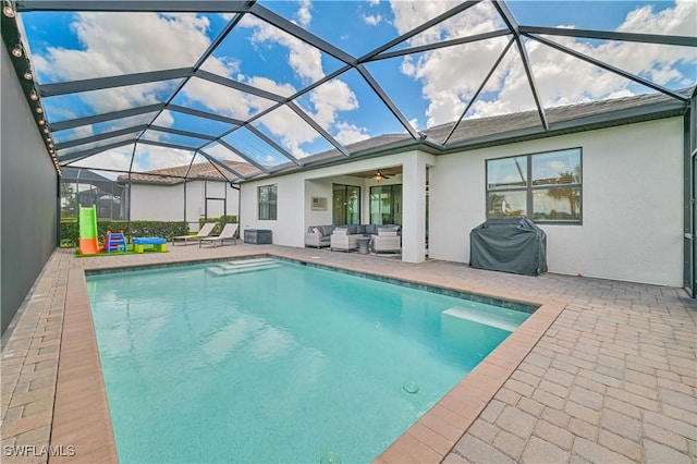 view of swimming pool with area for grilling, a patio area, ceiling fan, and glass enclosure