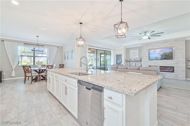 kitchen with white cabinetry, decorative light fixtures, stainless steel dishwasher, and an island with sink