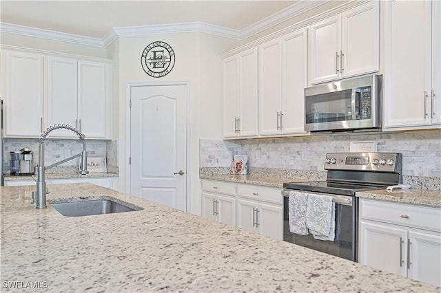 kitchen featuring sink, crown molding, white cabinets, stainless steel appliances, and backsplash