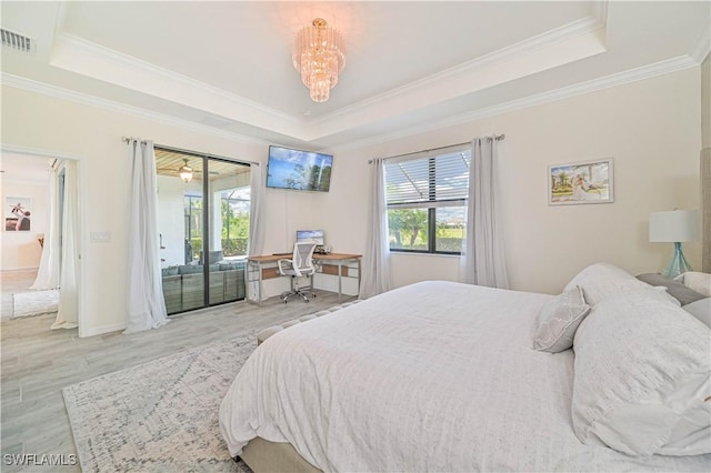 bedroom with a chandelier, a raised ceiling, light hardwood / wood-style floors, and access to outside