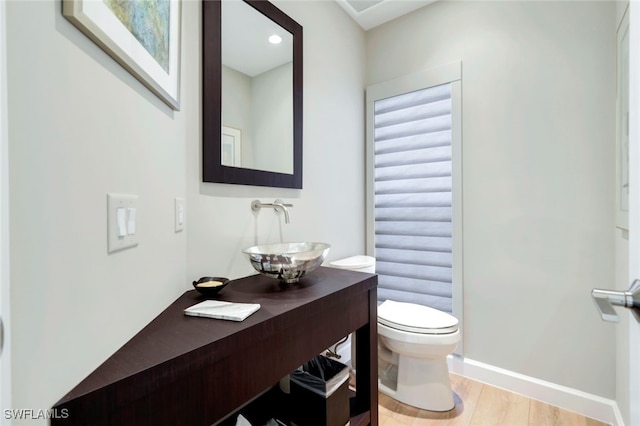 bathroom with vanity, hardwood / wood-style flooring, and toilet