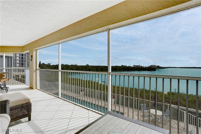 sunroom featuring a water view