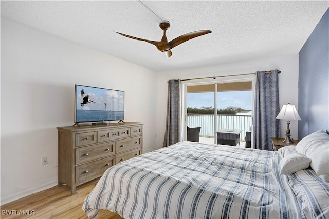 bedroom featuring access to outside, ceiling fan, a textured ceiling, and light wood-type flooring