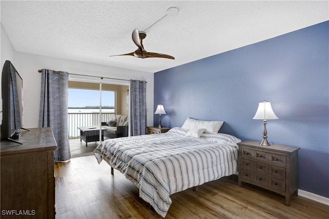 bedroom featuring access to exterior, hardwood / wood-style floors, a textured ceiling, and ceiling fan