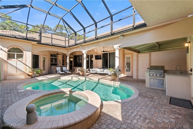 view of swimming pool with a patio area, an in ground hot tub, an outdoor kitchen, ceiling fan, and grilling area