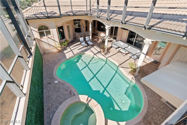 view of swimming pool featuring an in ground hot tub and a patio