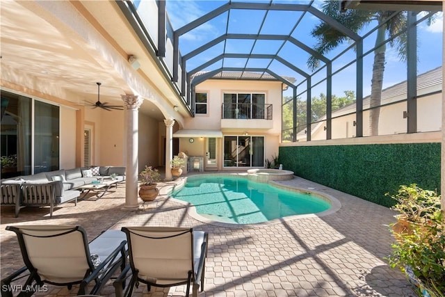 view of pool featuring glass enclosure, an outdoor living space, ceiling fan, and a patio