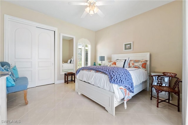 bedroom featuring ceiling fan, light tile patterned floors, and a closet