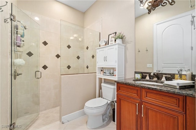 bathroom featuring a shower with door, toilet, vanity, and tile patterned flooring