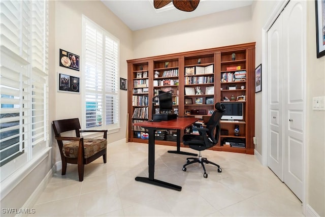 office space featuring ceiling fan, a healthy amount of sunlight, and light tile patterned floors