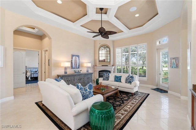 tiled living room with ceiling fan and coffered ceiling