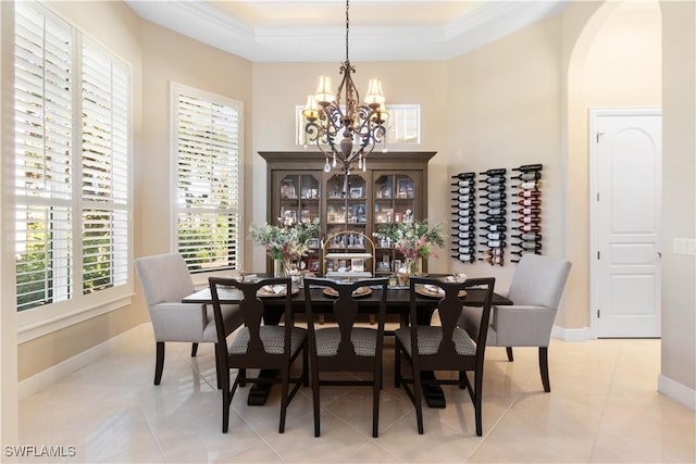 tiled dining space featuring a tray ceiling and a notable chandelier