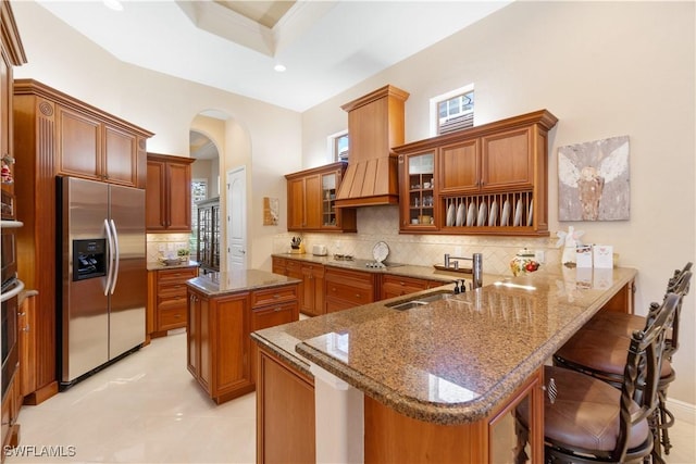 kitchen with appliances with stainless steel finishes, a kitchen breakfast bar, sink, a kitchen island, and kitchen peninsula