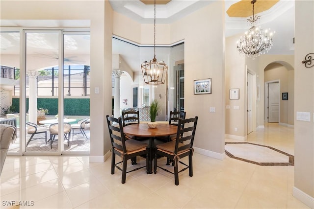 dining area featuring a high ceiling, light tile patterned floors, ornamental molding, and a notable chandelier