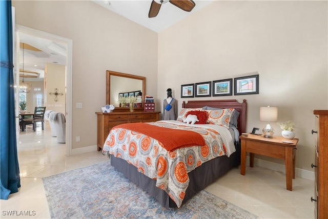 tiled bedroom featuring ceiling fan with notable chandelier