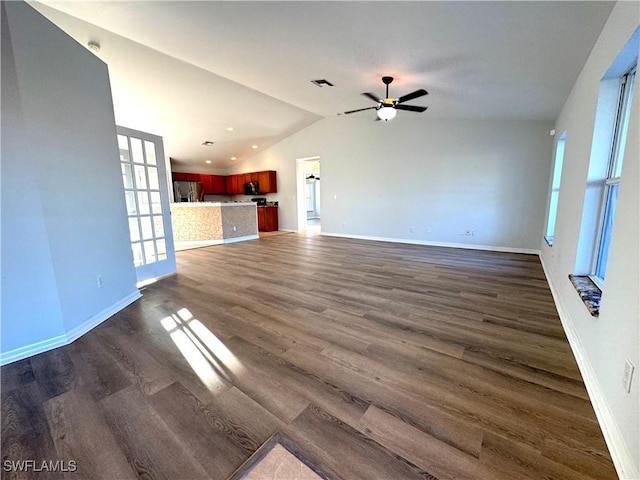 unfurnished living room featuring ceiling fan, dark wood-type flooring, and vaulted ceiling