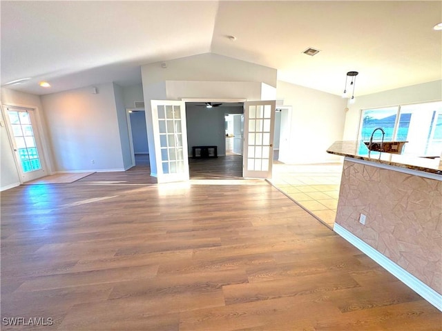 unfurnished living room featuring french doors, wood-type flooring, and lofted ceiling