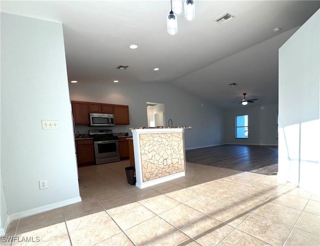 kitchen with lofted ceiling, ceiling fan, light tile patterned floors, appliances with stainless steel finishes, and decorative light fixtures