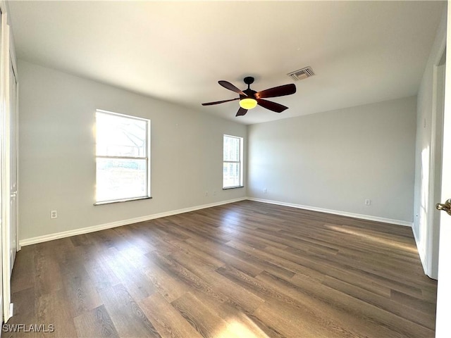 spare room with ceiling fan and dark wood-type flooring