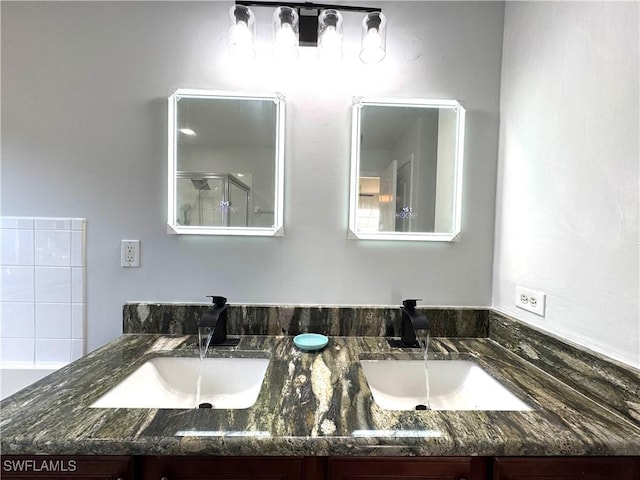 bathroom featuring vanity and a shower with door