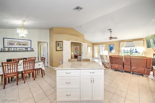 kitchen featuring light stone countertops, hanging light fixtures, lofted ceiling, white cabinets, and ceiling fan with notable chandelier