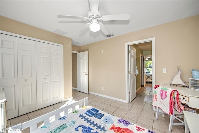 bedroom with ceiling fan, light tile patterned floors, and a closet