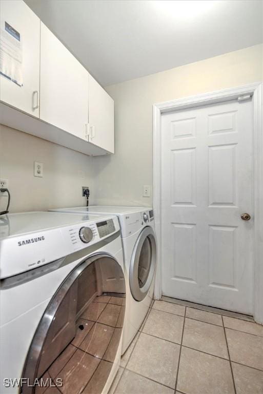 washroom with cabinets, independent washer and dryer, and light tile patterned floors