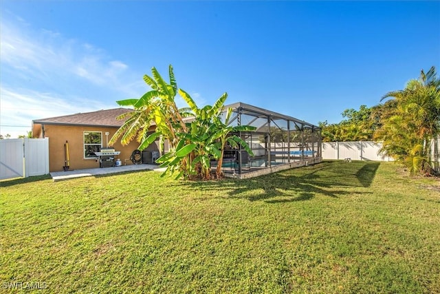 view of yard with a patio, a fenced in pool, and a lanai