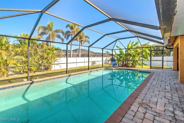 view of pool featuring glass enclosure and a patio area