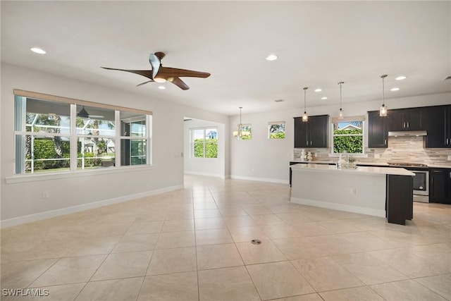 kitchen featuring decorative light fixtures, a healthy amount of sunlight, a kitchen island, and stainless steel range with electric cooktop