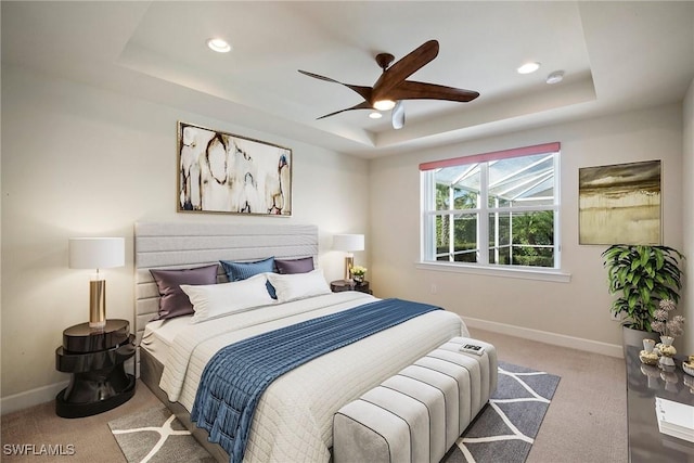 bedroom featuring a tray ceiling, ceiling fan, and light colored carpet