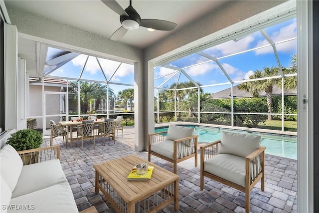 sunroom / solarium with ceiling fan and a swimming pool