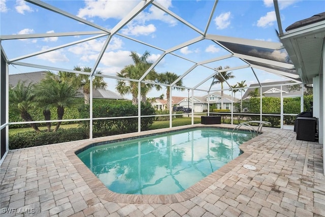 view of pool featuring glass enclosure and a patio