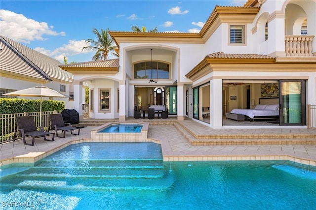 back of property featuring a pool with hot tub, ceiling fan, and a patio area