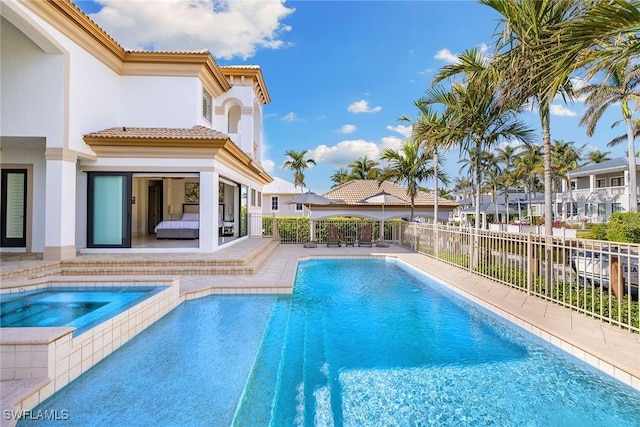 view of swimming pool featuring an in ground hot tub and a patio