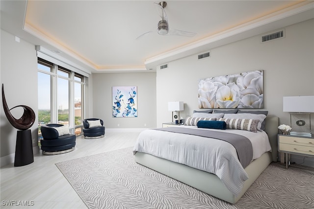 bedroom with a tray ceiling and ceiling fan