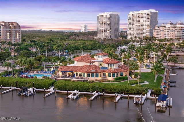 aerial view at dusk featuring a water view