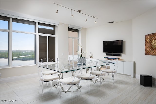 tiled dining space featuring track lighting