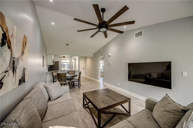 living room with light hardwood / wood-style floors, vaulted ceiling, and ceiling fan