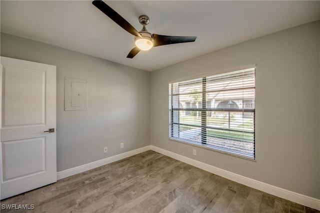 unfurnished room featuring ceiling fan, light hardwood / wood-style floors, and electric panel