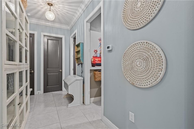 hallway featuring crown molding and light tile patterned floors