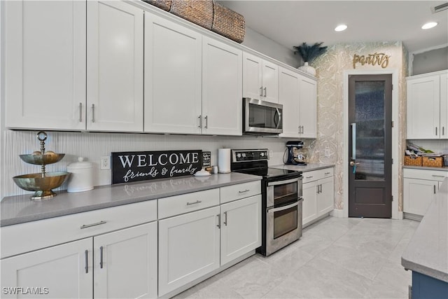 kitchen featuring backsplash, white cabinetry, and appliances with stainless steel finishes