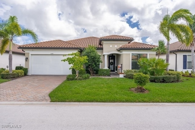 mediterranean / spanish home with a garage and a front lawn