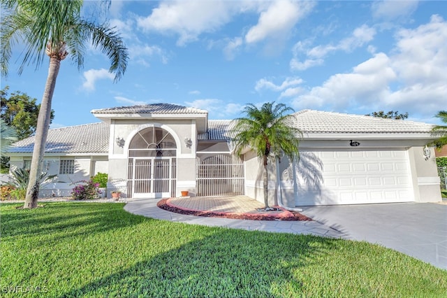 mediterranean / spanish house featuring a front yard and a garage