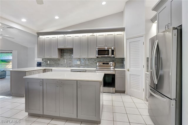 kitchen with a kitchen island, lofted ceiling, and appliances with stainless steel finishes